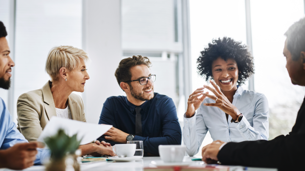 Menschen sitzen zusammen an einem Tisch und unterhalten sich.